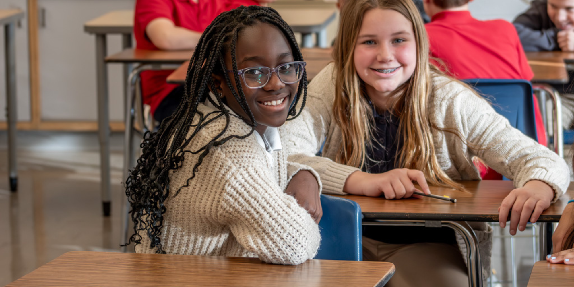 Two OLOL students sitting at desks