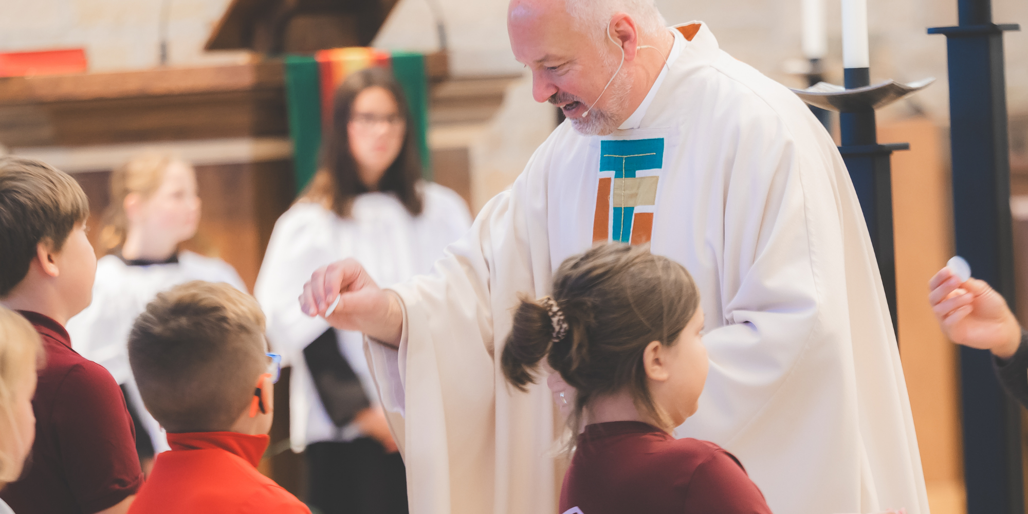 Priest at OLOL giving Communion